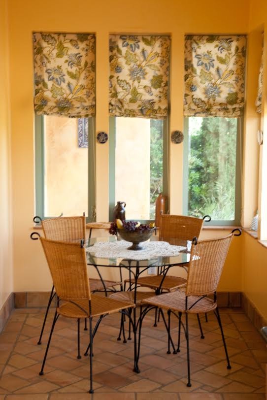 Immagine di una piccola sala da pranzo mediterranea chiusa con pareti gialle, pavimento in terracotta e nessun camino