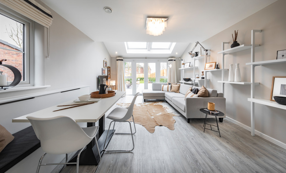 Example of a mid-sized trendy light wood floor and gray floor dining room design in Manchester with gray walls