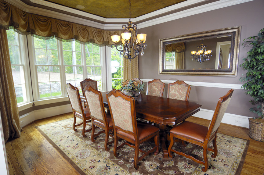 Exemple d'une salle à manger ouverte sur le salon chic de taille moyenne avec un mur violet et un sol en bois brun.