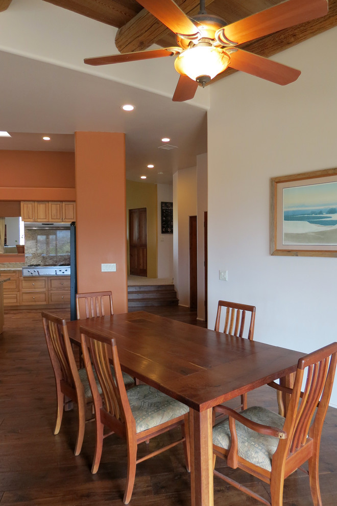 Aménagement d'une grande salle à manger ouverte sur la cuisine contemporaine avec un mur orange et parquet foncé.