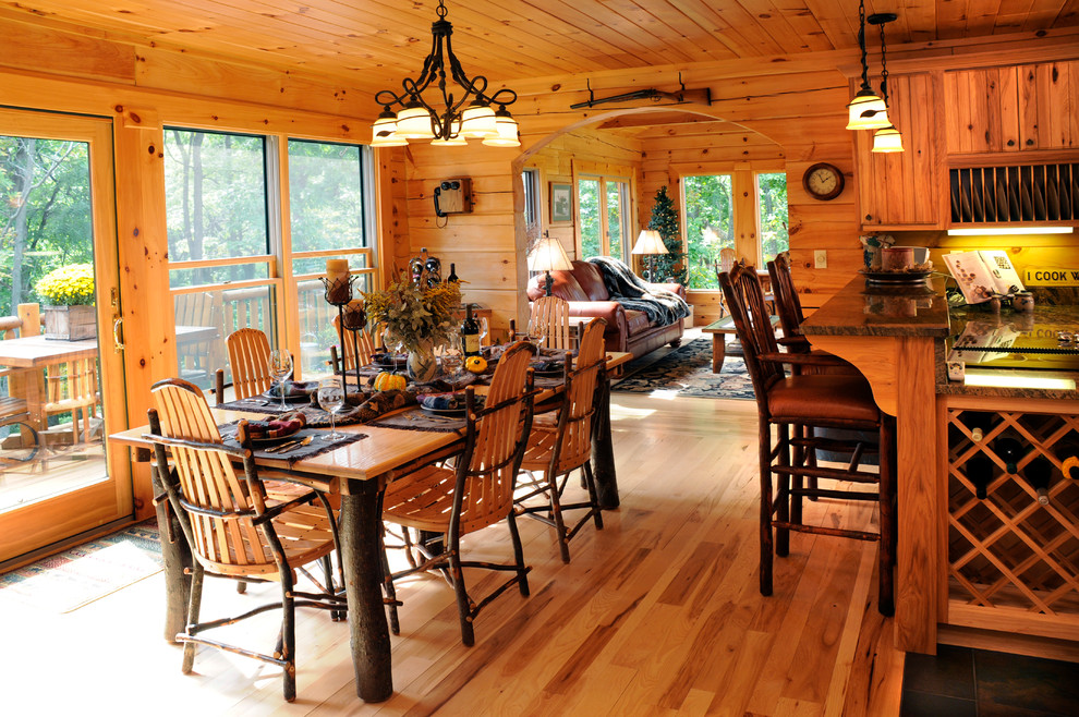 Esempio di una sala da pranzo aperta verso la cucina rustica di medie dimensioni con pareti marroni e parquet chiaro