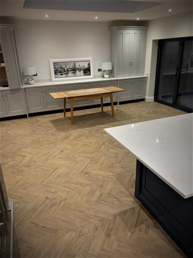 Foto di una grande sala da pranzo aperta verso la cucina minimalista con pareti grigie, pavimento in vinile e pavimento grigio