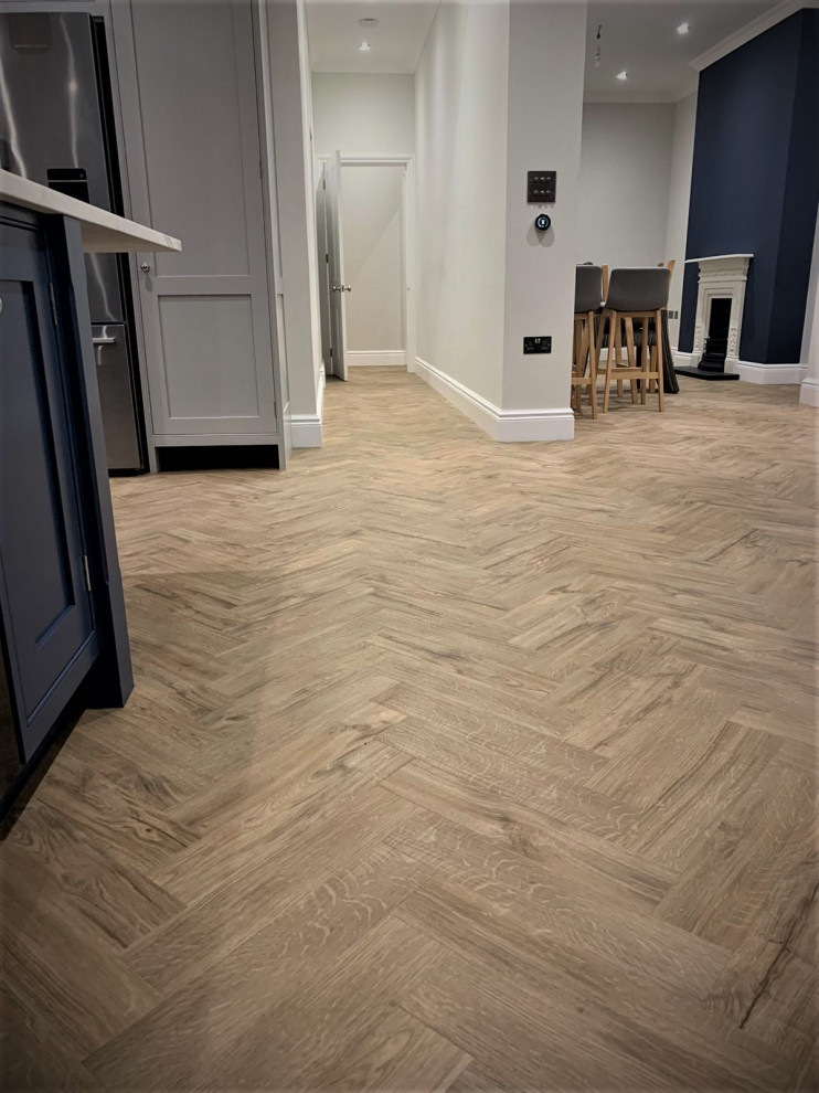 Large minimalist vinyl floor and gray floor kitchen/dining room combo photo in Hertfordshire with gray walls