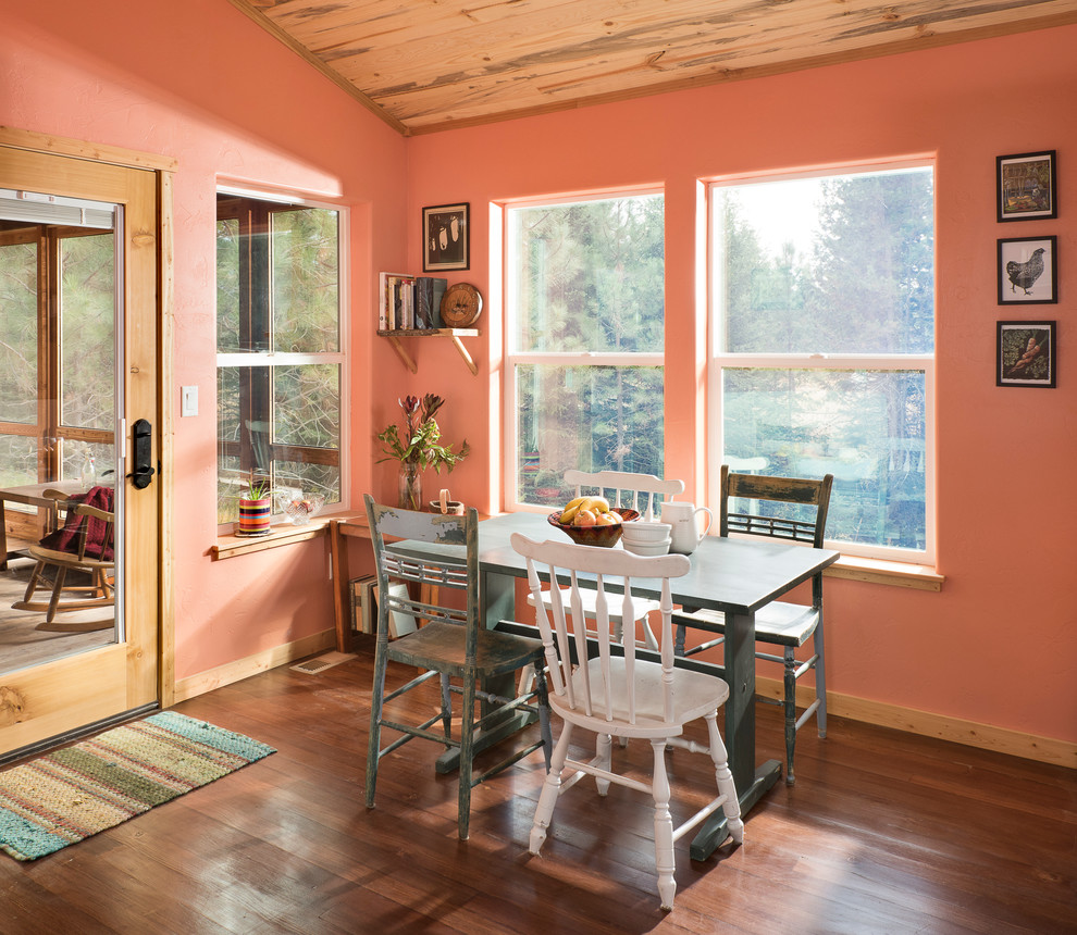 Inredning av ett rustikt litet kök med matplats, med mellanmörkt trägolv och rosa väggar