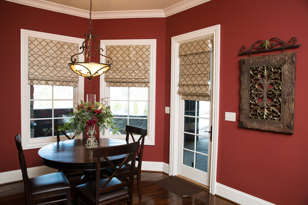 Aménagement d'une salle à manger ouverte sur le salon classique de taille moyenne avec un mur rouge, parquet foncé, aucune cheminée et un sol marron.