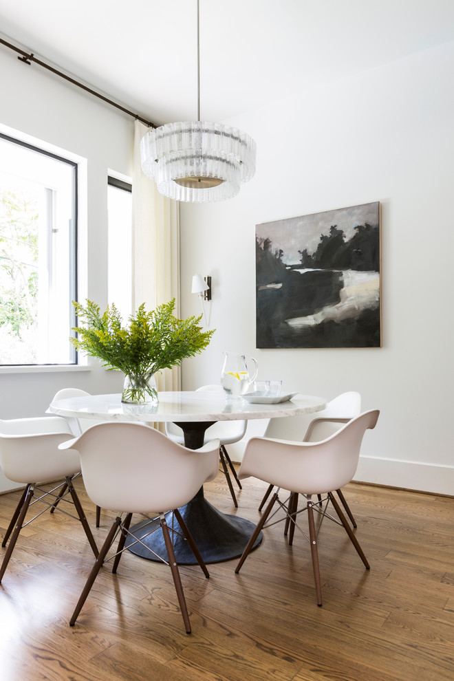This is an example of a contemporary dining room in Houston with white walls and medium hardwood flooring.