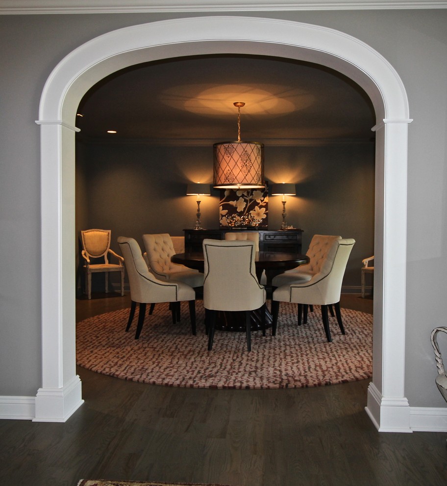 Cette image montre une salle à manger ouverte sur la cuisine minimaliste de taille moyenne avec un mur gris et un sol en bois brun.