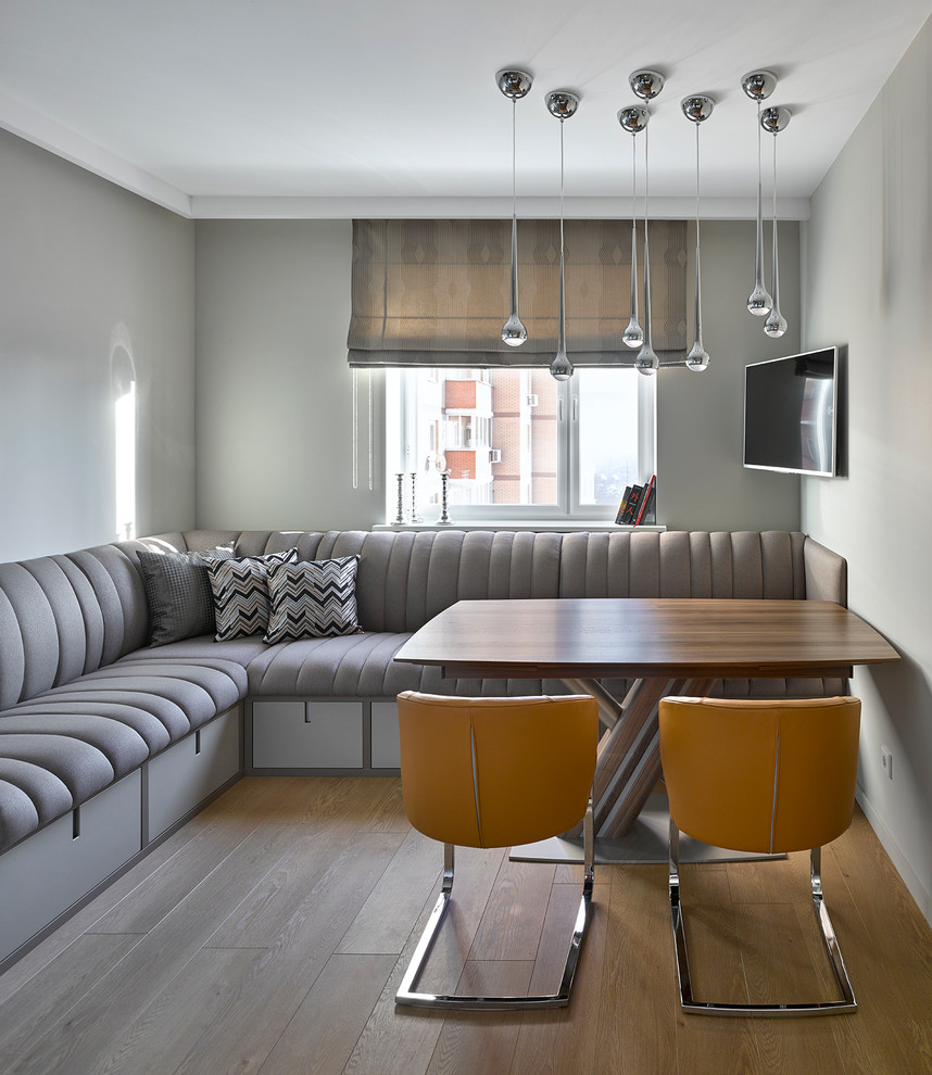 Moderne Wohnküche ohne Kamin mit grauer Wandfarbe und braunem Holzboden in Moskau