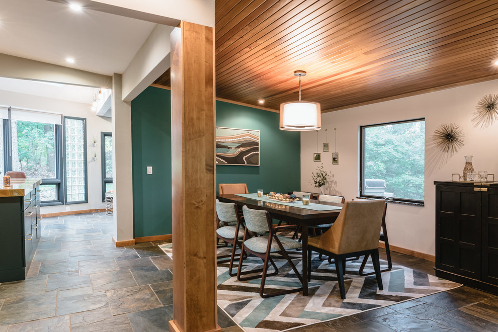 Foto di una sala da pranzo aperta verso la cucina moderna con pareti verdi, pavimento in ardesia e pavimento multicolore