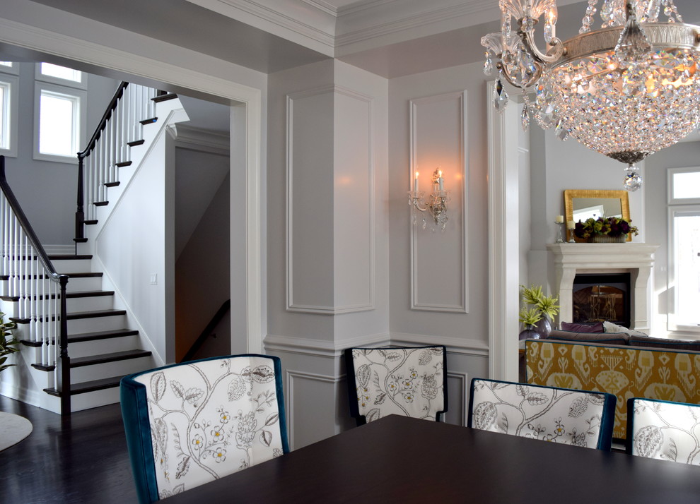 Пример оригинального дизайна: гостиная-столовая среднего размера в классическом стиле с белыми стенами, темным паркетным полом, стандартным камином и фасадом камина из камня