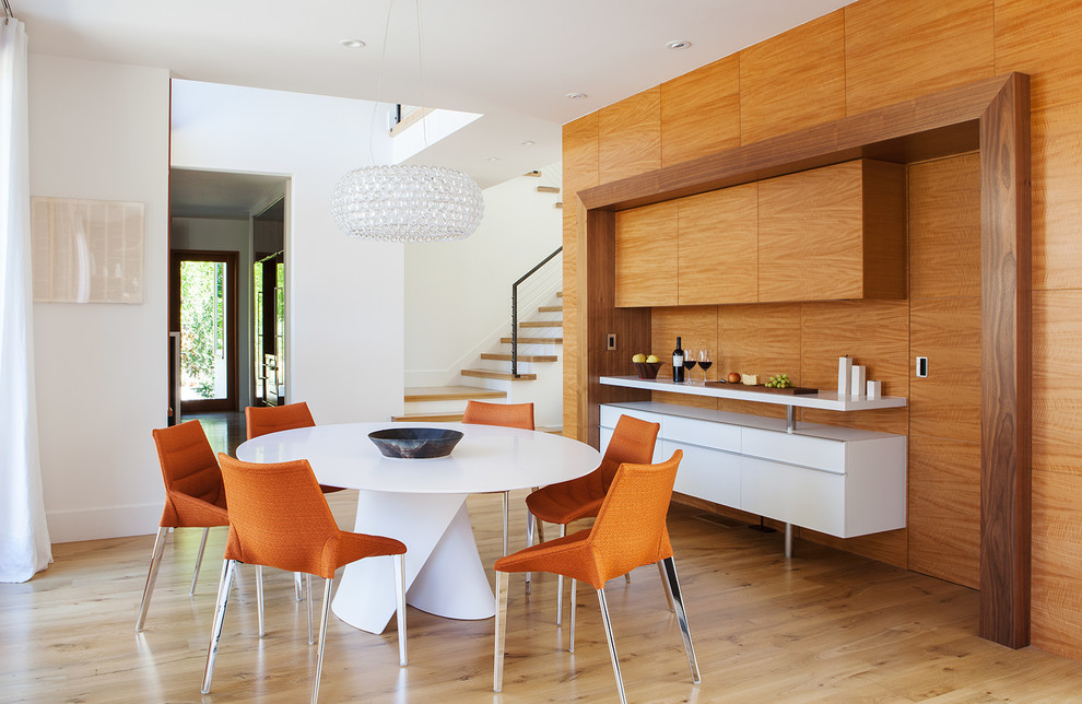 Immagine di una sala da pranzo design con pareti bianche e pavimento in legno massello medio