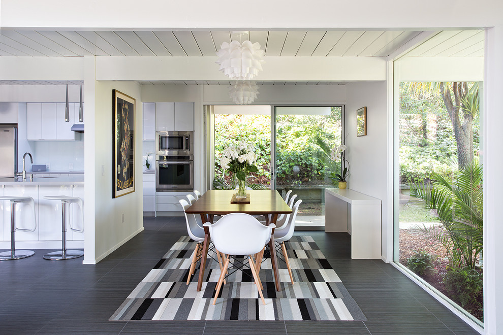 Inspiration pour une salle à manger ouverte sur la cuisine vintage avec un mur blanc et un sol en carrelage de céramique.