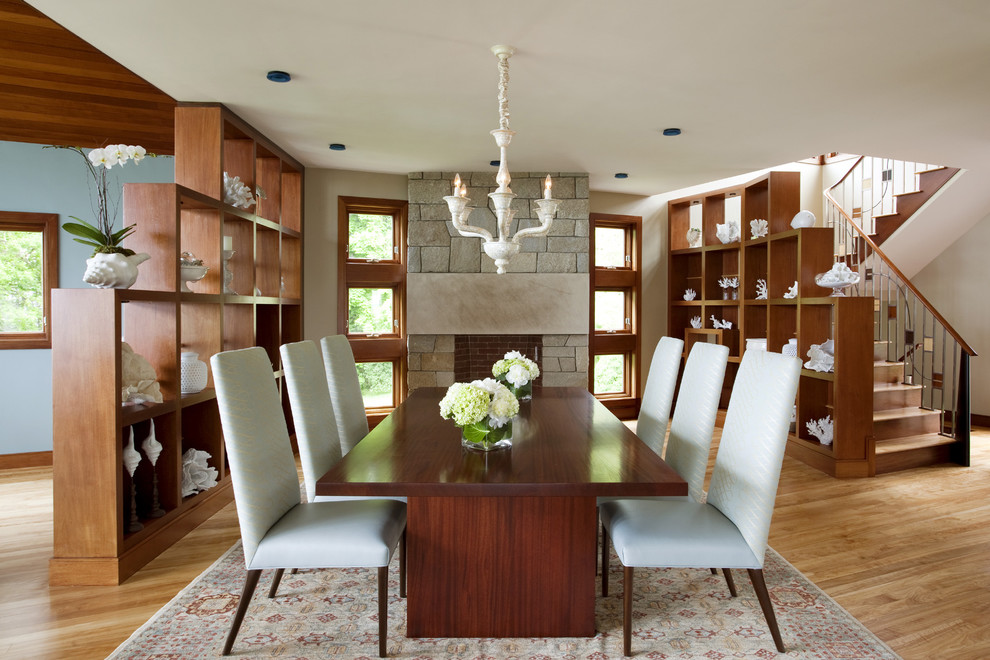 Contemporary dining room in Boston with a stone fireplace surround.