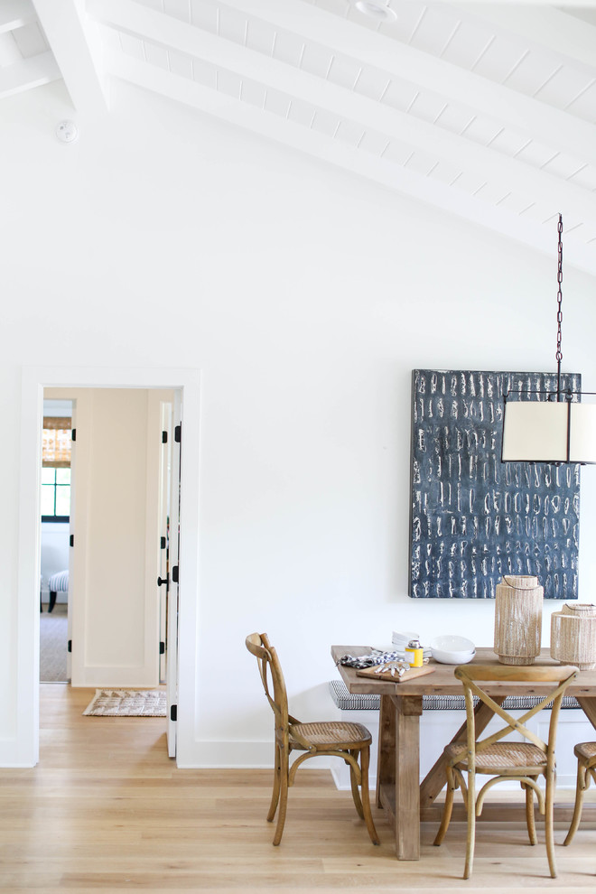 Esempio di una sala da pranzo aperta verso la cucina country con pareti bianche e parquet chiaro