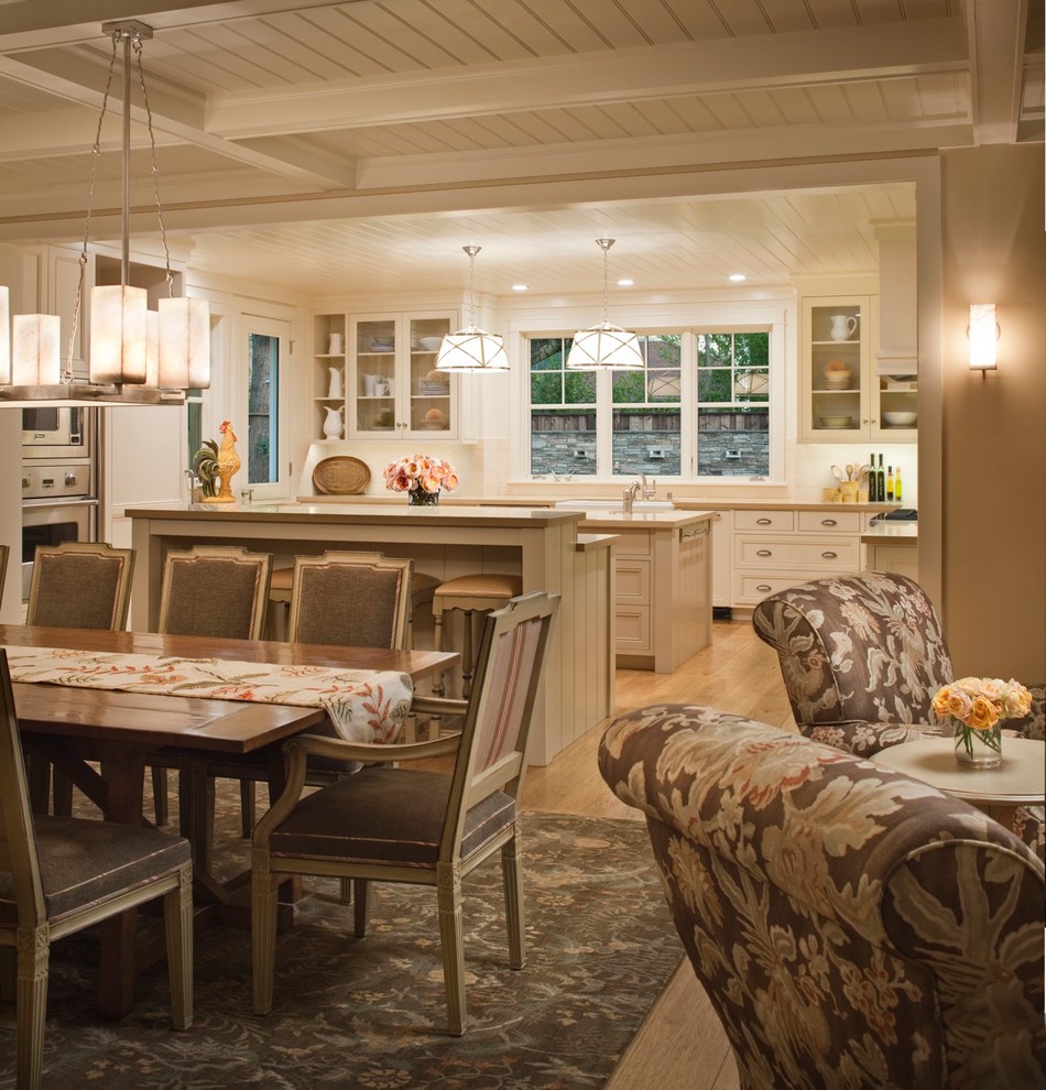 Foto di una grande sala da pranzo aperta verso la cucina country con parquet chiaro, pareti beige, nessun camino e pavimento marrone