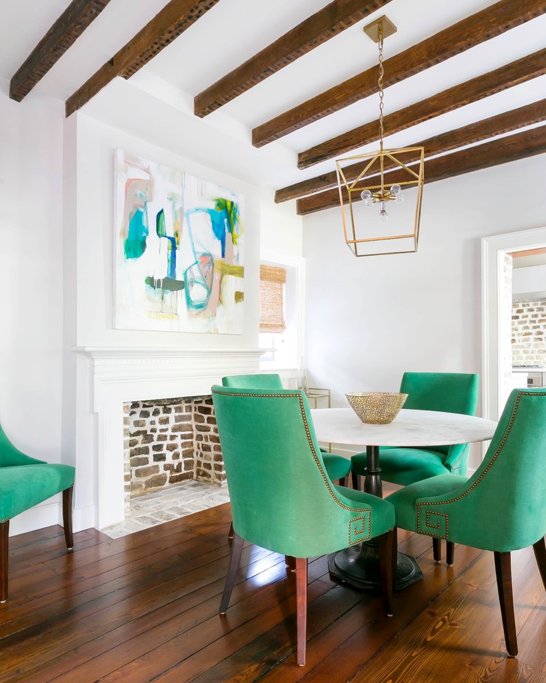 Geschlossenes, Kleines Modernes Esszimmer mit weißer Wandfarbe, braunem Holzboden, Kamin, Kaminumrandung aus Holz und braunem Boden in Charleston