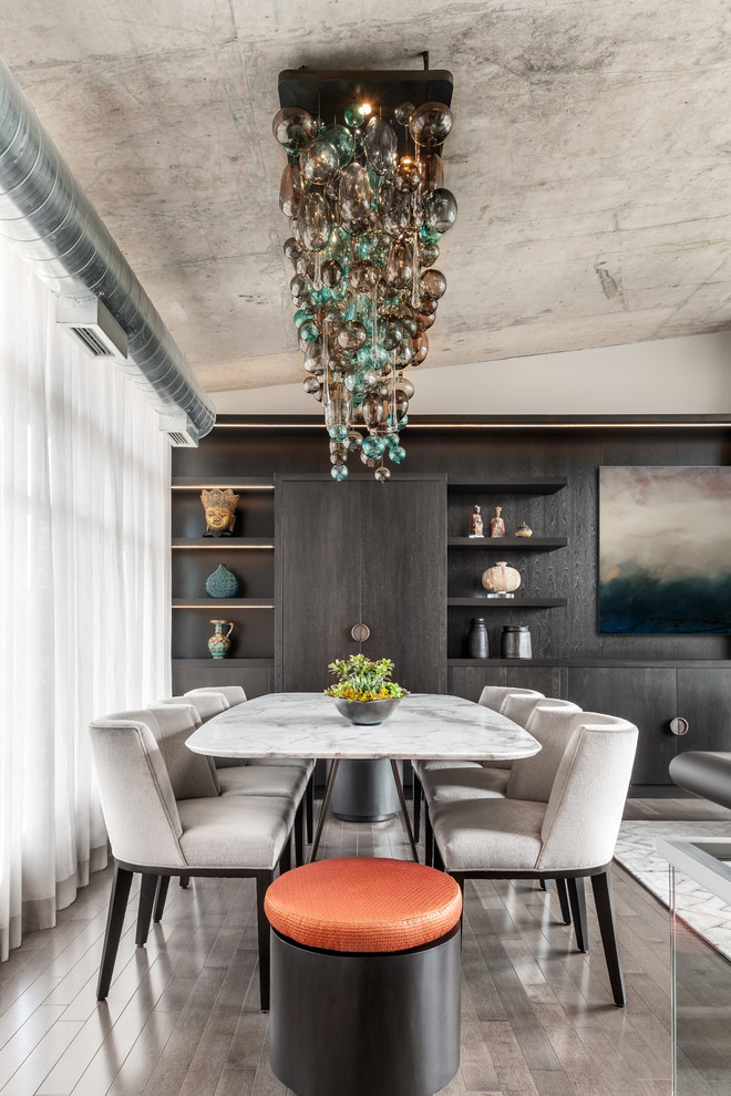 Aménagement d'une petite salle à manger ouverte sur le salon contemporaine avec un mur gris, parquet foncé et un sol marron.