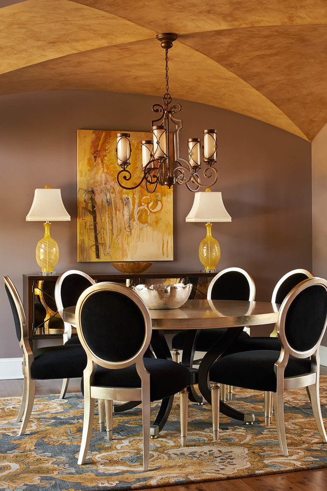 Idée de décoration pour une salle à manger tradition fermée et de taille moyenne avec un mur gris, un sol en bois brun, aucune cheminée et éclairage.