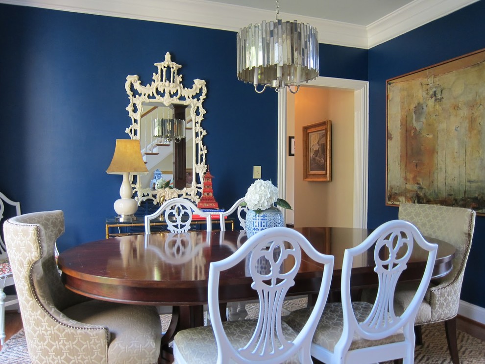 Réalisation d'une grande salle à manger ouverte sur la cuisine minimaliste avec un mur bleu et parquet foncé.
