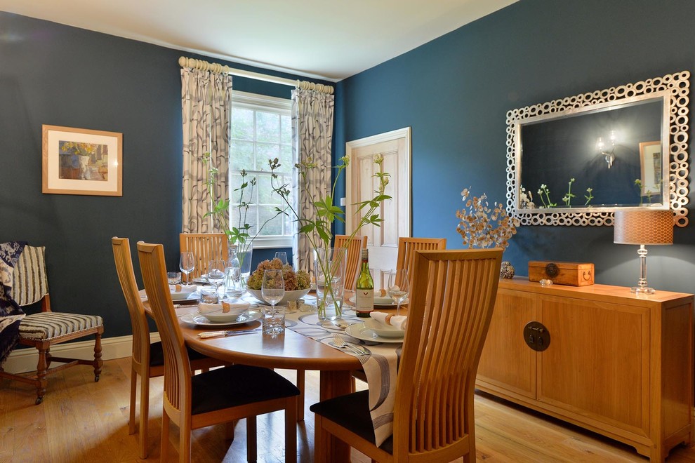 Idee per una sala da pranzo contemporanea chiusa e di medie dimensioni con pareti blu, parquet chiaro e nessun camino