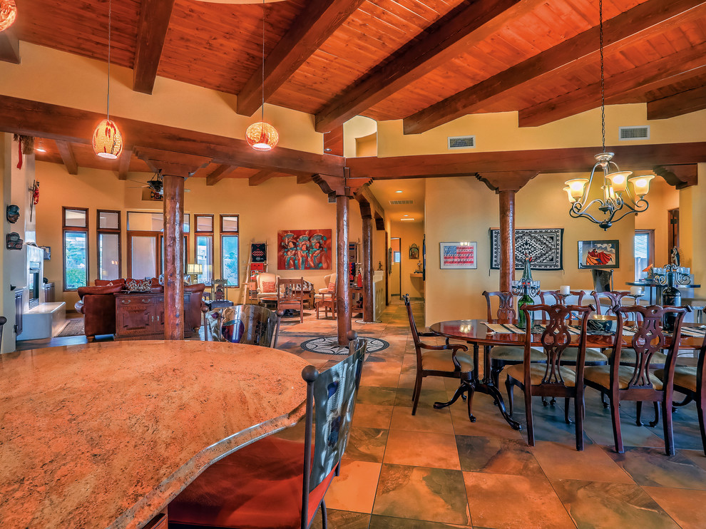 Immagine di una grande sala da pranzo aperta verso la cucina stile americano con pareti multicolore, pavimento in ardesia e pavimento multicolore