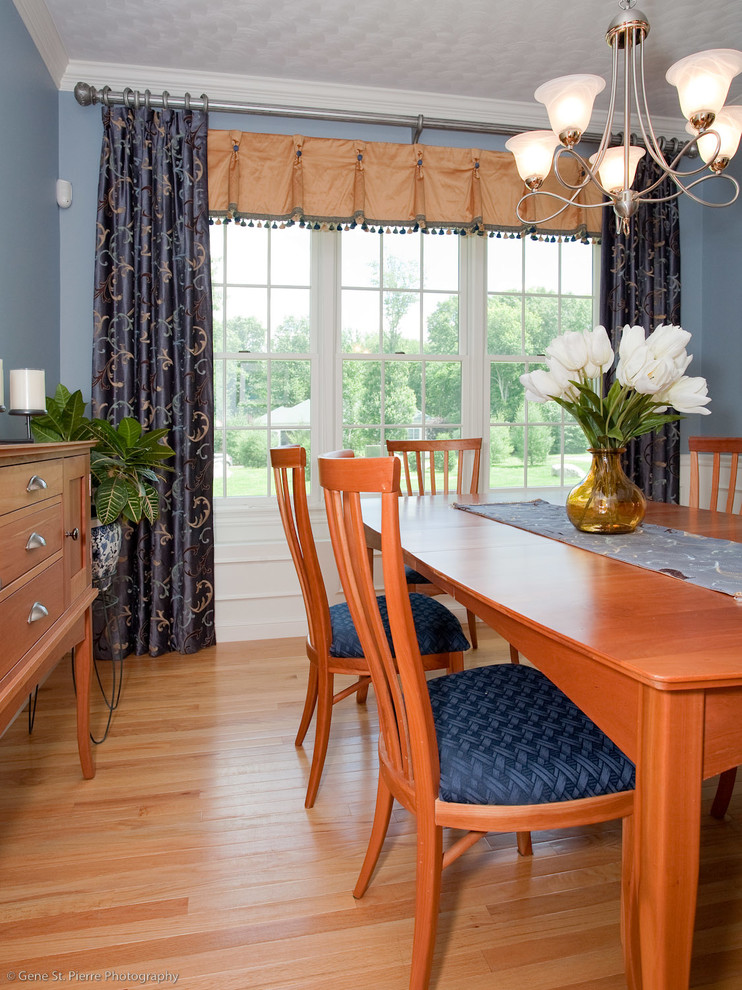 Réalisation d'une salle à manger tradition de taille moyenne avec un mur bleu, parquet clair, aucune cheminée et un sol marron.