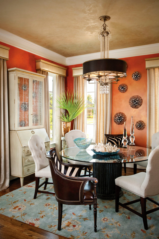 Traditional dining room in Charlotte with orange walls and dark hardwood flooring.
