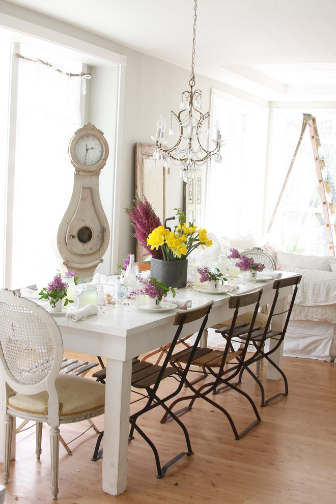 Cette photo montre une salle à manger romantique avec un mur blanc et un sol en bois brun.