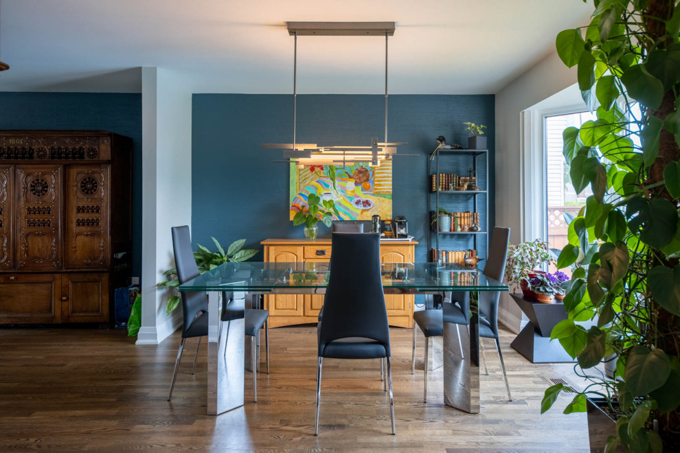 Inspiration pour une salle à manger ouverte sur le salon design de taille moyenne avec un sol en bois brun, un sol marron, un mur bleu, aucune cheminée et du papier peint.