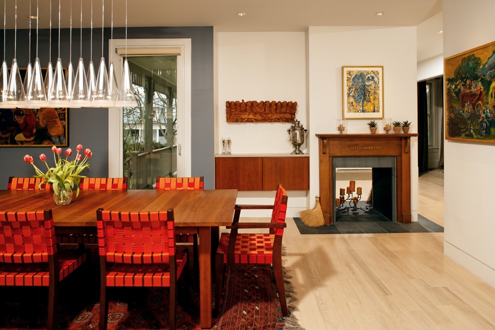 Photo of a medium sized contemporary open plan dining room in DC Metro with a two-sided fireplace, white walls, light hardwood flooring, a wooden fireplace surround and beige floors.