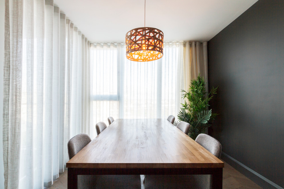 Photo of a medium sized contemporary open plan dining room in Dublin with black walls, dark hardwood flooring and brown floors.