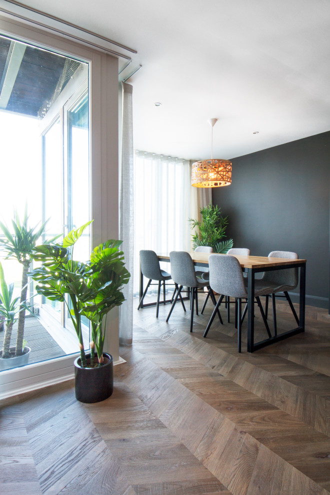Medium sized contemporary open plan dining room in Dublin with black walls, dark hardwood flooring and brown floors.