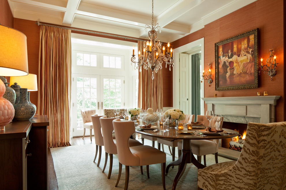 Immagine di una sala da pranzo classica chiusa con parquet scuro, camino classico e pareti arancioni