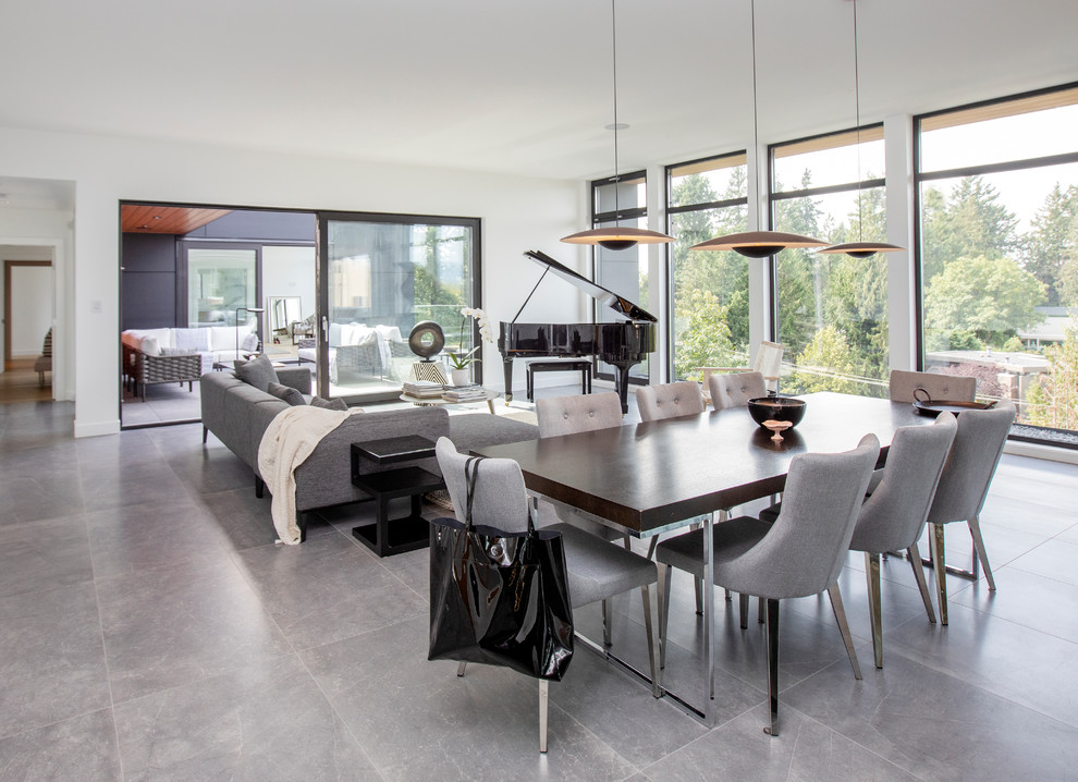 Cette image montre une salle à manger ouverte sur la cuisine minimaliste de taille moyenne avec un mur blanc, un sol en carrelage de porcelaine, aucune cheminée et un sol gris.