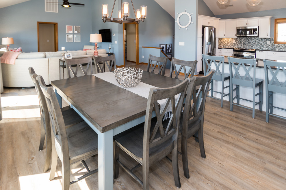 Medium sized beach style open plan dining room in Other with blue walls and vinyl flooring.