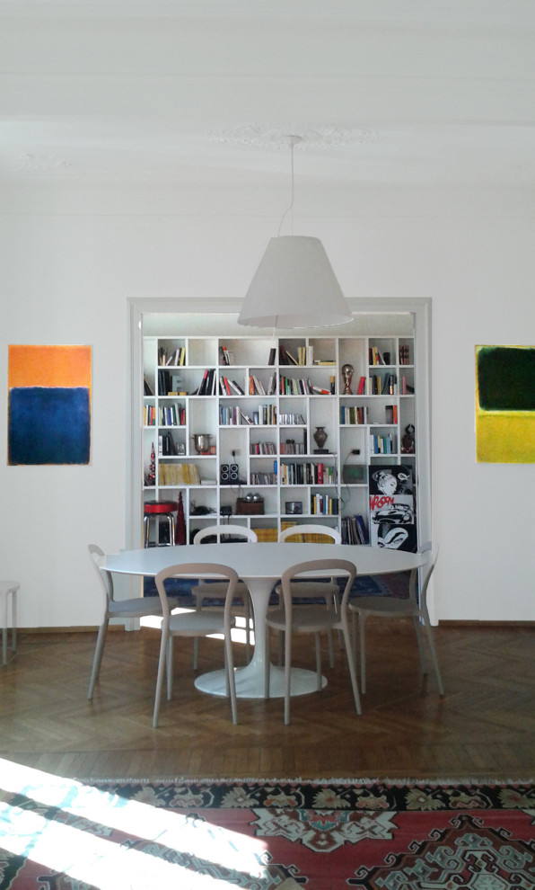 Immagine di una sala da pranzo aperta verso il soggiorno design con pareti bianche, pavimento in legno massello medio e pavimento marrone