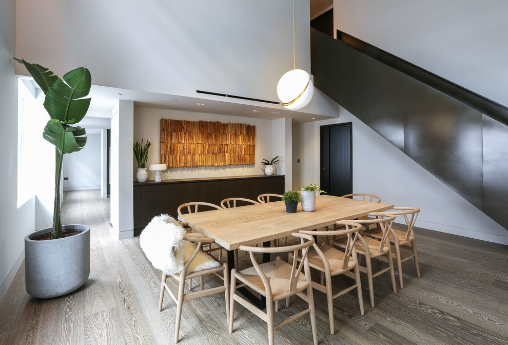 Idée de décoration pour une salle à manger ouverte sur la cuisine design de taille moyenne avec un mur blanc, parquet clair et aucune cheminée.