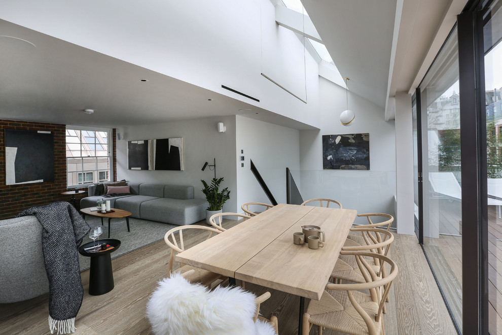 Mittelgroße Moderne Wohnküche ohne Kamin mit weißer Wandfarbe und hellem Holzboden in London