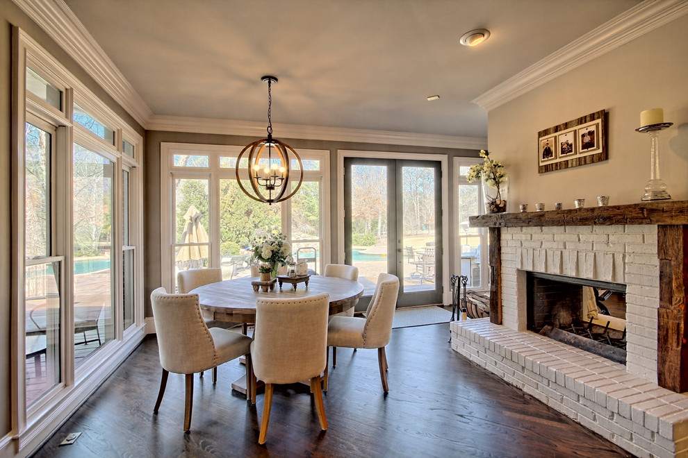 Design ideas for a country dining room in Atlanta with grey walls, medium hardwood flooring, a two-sided fireplace, a brick fireplace surround and feature lighting.