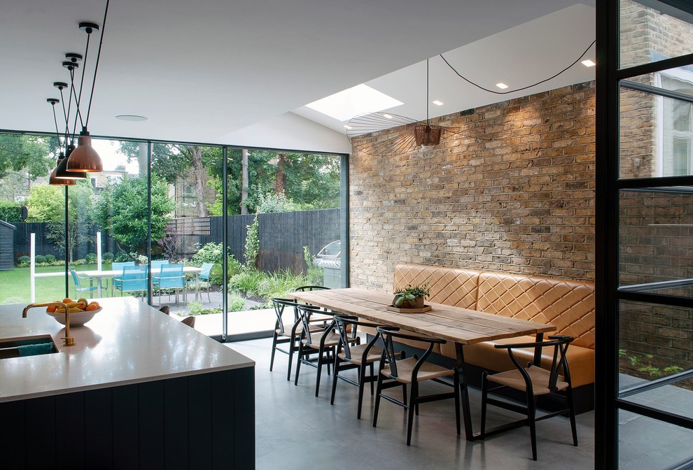 Immagine di una sala da pranzo aperta verso la cucina contemporanea di medie dimensioni con pavimento in cemento e pavimento grigio