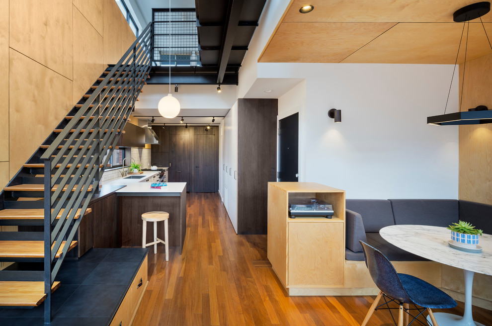 Idee per una piccola sala da pranzo aperta verso la cucina minimalista con pareti multicolore e parquet chiaro