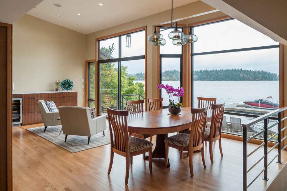 Immagine di una sala da pranzo aperta verso il soggiorno design con pareti beige e pavimento in legno massello medio