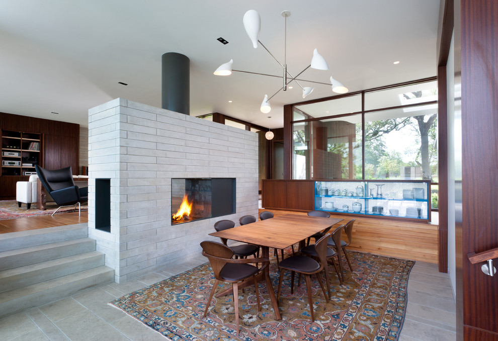 Photo of a medium sized retro enclosed dining room in Austin with a two-sided fireplace and a tiled fireplace surround.