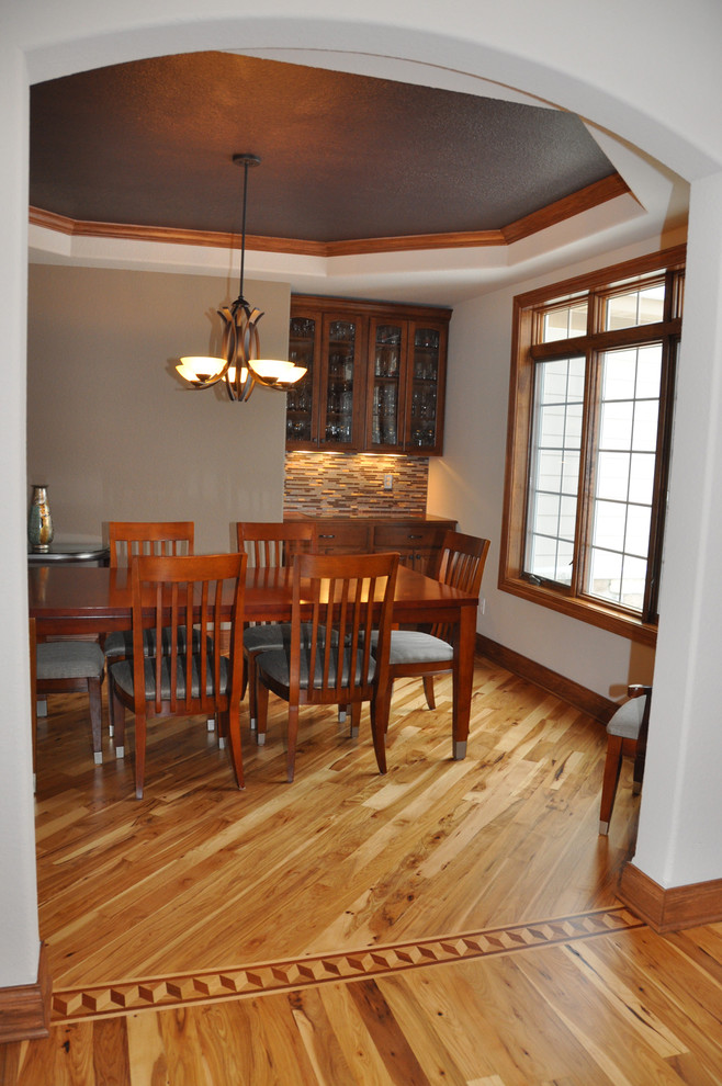 Aménagement d'une salle à manger classique fermée et de taille moyenne avec un mur beige et un sol en bois brun.