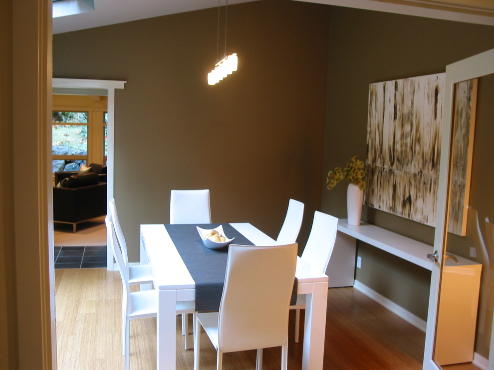 Стильный дизайн: столовая в современном стиле с зелеными стенами и полом из бамбука - последний тренд
