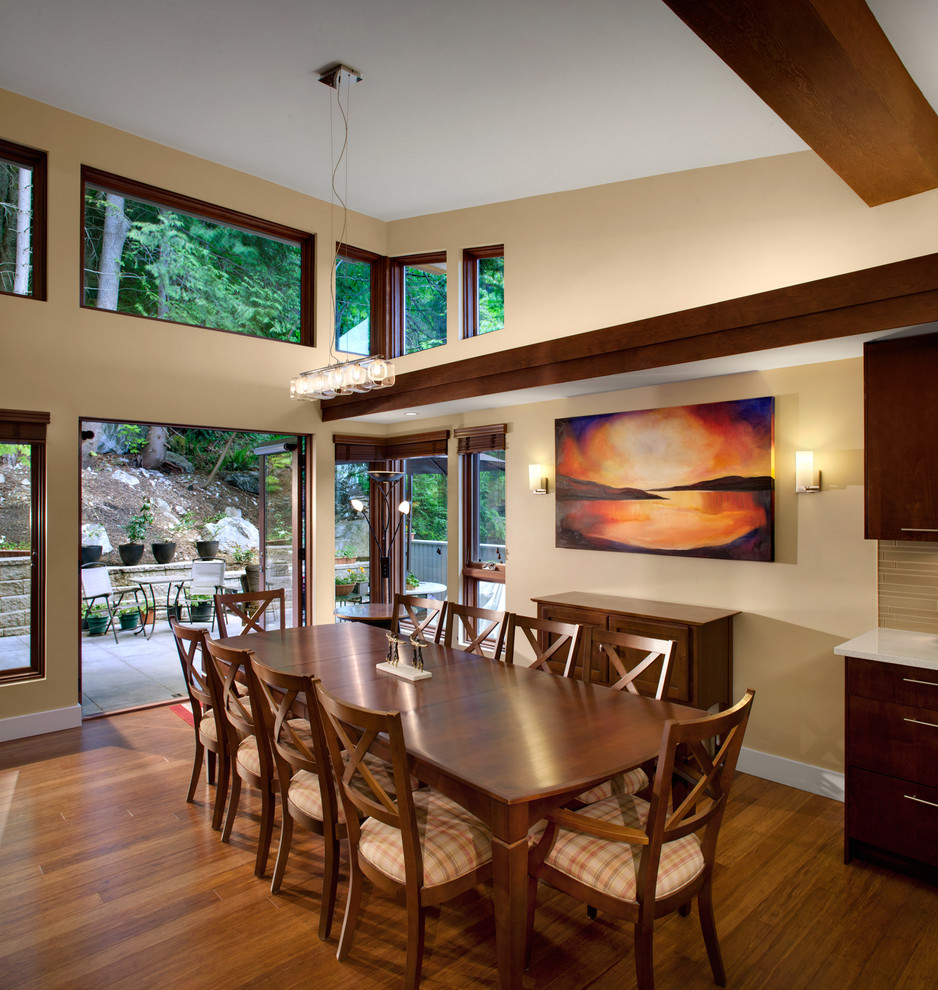 Modelo de comedor contemporáneo con paredes beige y suelo de madera oscura