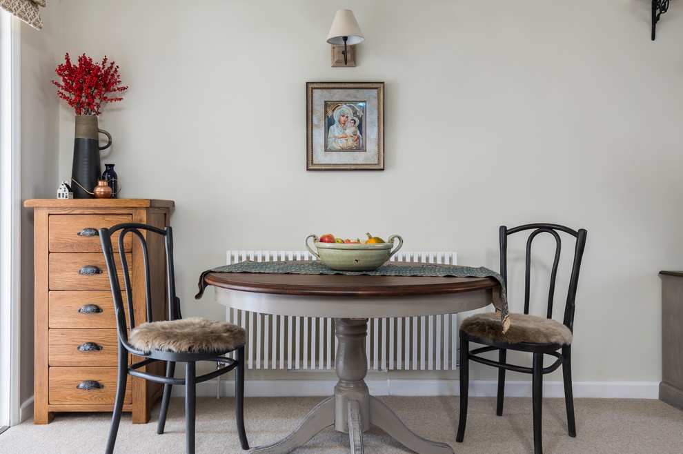 Cette image montre une salle à manger ouverte sur le salon traditionnelle avec un mur gris et moquette.