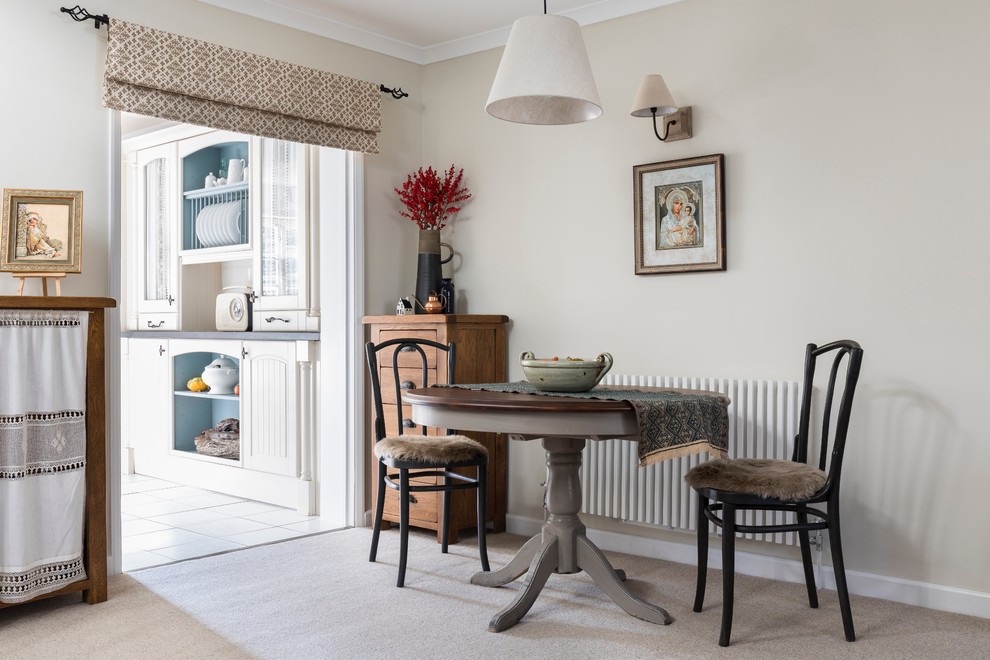 Esempio di una sala da pranzo aperta verso il soggiorno chic con moquette e pareti beige