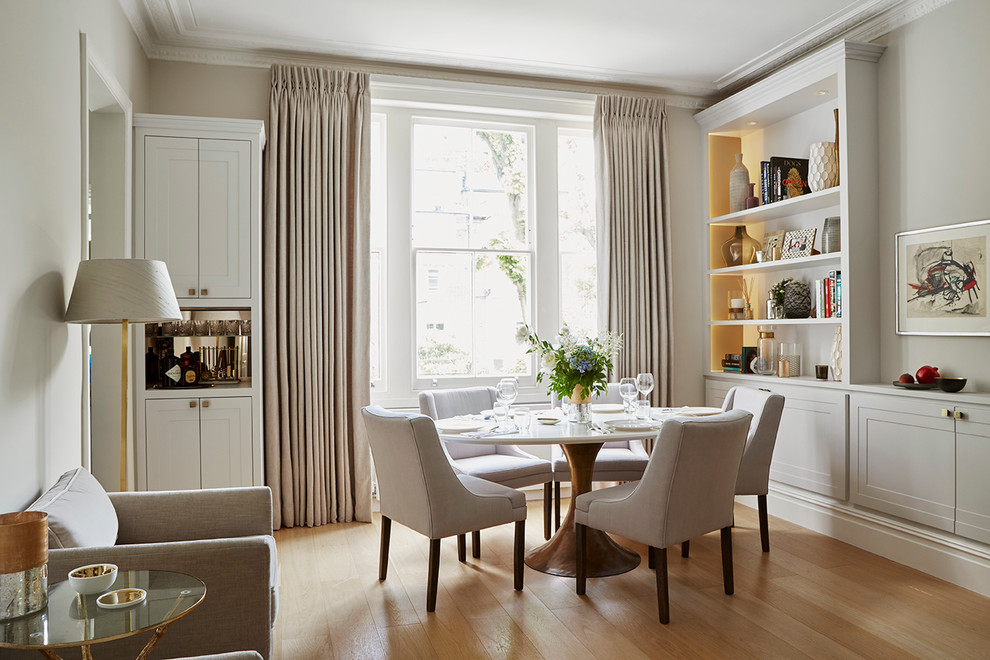 Classic dining room in London with grey walls and light hardwood flooring.