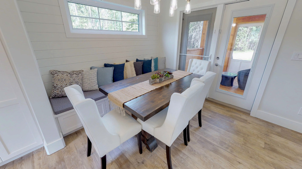 Esempio di una sala da pranzo aperta verso la cucina stile marinaro di medie dimensioni con pareti bianche, parquet chiaro, nessun camino e pavimento marrone